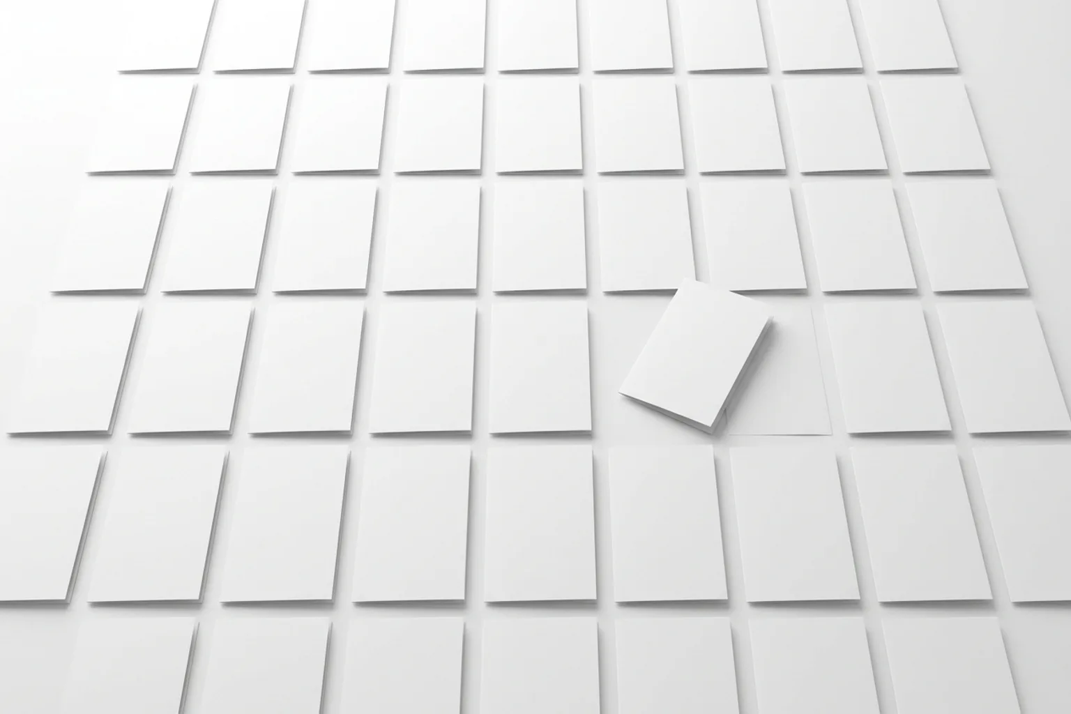 Vue du dessus d'une grande table blanche couverte d'imprimés pliés identiques alignés en grille régulière